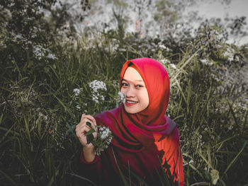 A woman who is sitting among flowers in the dry season