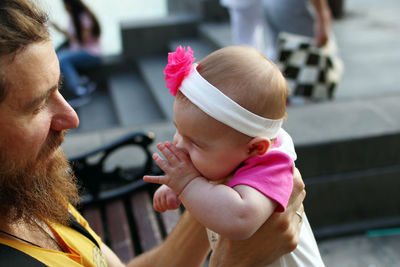 Side view of father holding daughter outdoors