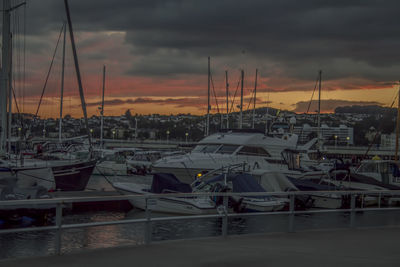 View of harbor against cloudy sky during sunset