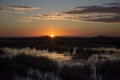 Scenic view of lake against sky during sunset