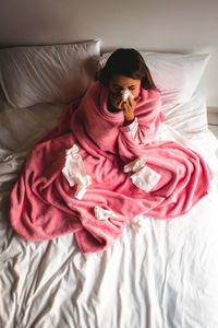 Midsection of woman relaxing on bed at home