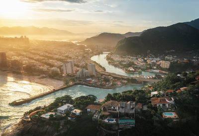 High angle view of illuminated cityscape against sky during sunset