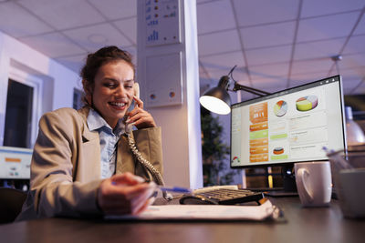 Young woman using mobile phone in office