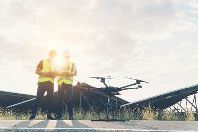 Man standing by vehicle against sky