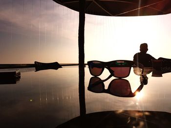 Reflection of man in sunglasses against sky