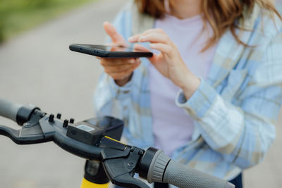 Midsection of woman using mobile phone