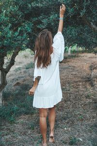 Rear view of woman standing in forest