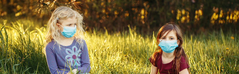 Portrait of girl wearing mask sitting outdoors