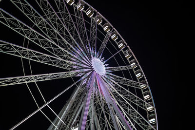 Low angle view of illuminated ferris wheel against sky at night