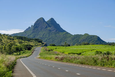 Road by mountain against sky