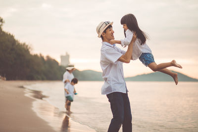 Rear view of mother and son at beach