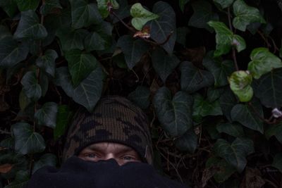 Portrait of person wearing mask against plants