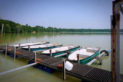 Boats moored in lake against clear sky