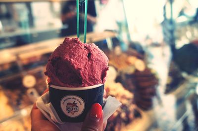 Close-up of woman holding ice cream at shop
