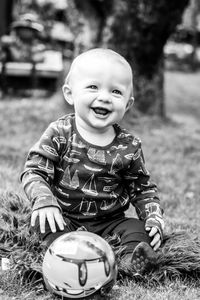 Smiling baby boy playing with ball at park