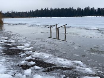 Wooden posts on snow covered field