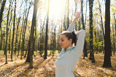 Girl doing fitness in nature on a sunny autumn forest