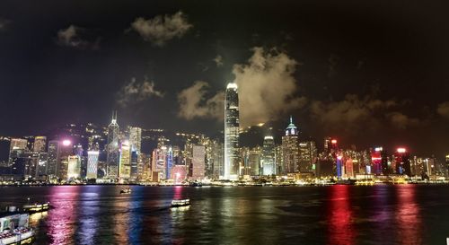 Illuminated buildings in city against sky at night