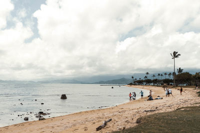 People on beach against sky