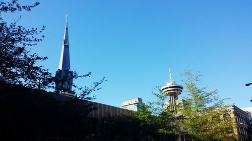 Low angle view of communications tower against clear blue sky