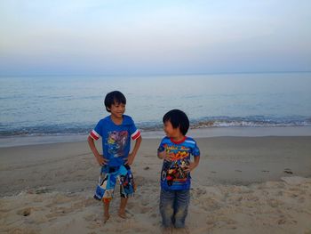 Full length of children on beach against sky