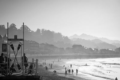 People on beach against clear sky