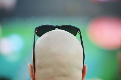 Rear view of man with shaved head wearing sunglasses