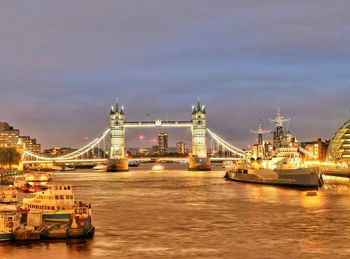 Bridge over river in city at night