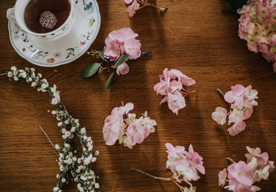 High angle view of flowers and black tea on table