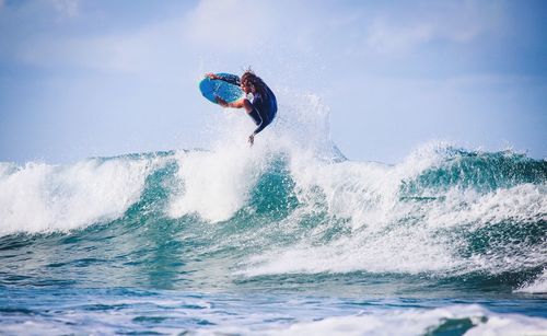 Man jumping in sea against sky