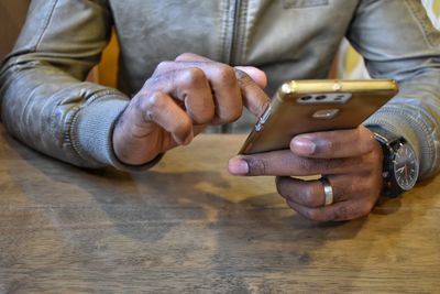 Midsection of man using smart phone