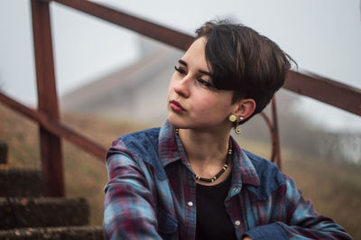 Woman looking away against railing