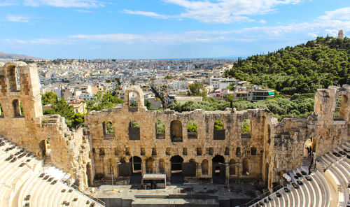 Odeon at acropolis of athens against sky