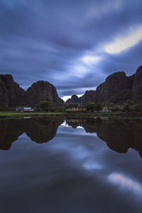 Scenic view of lake by mountains against sky