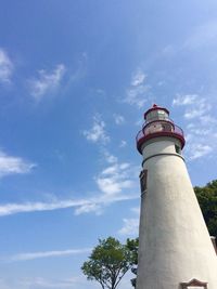 Low angle view of lighthouse by building against sky