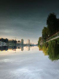 Scenic view of lake by buildings against sky