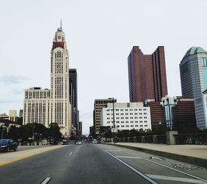 View of city street and buildings against sky