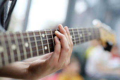 Close-up of man playing guitar