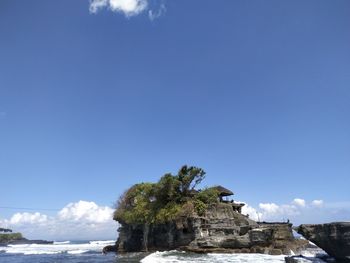 View of castle by sea against clear blue sky