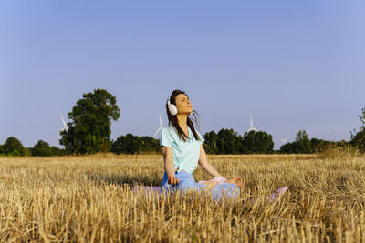 Woman standing on field against clear sky