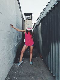 Rear view of woman standing by building