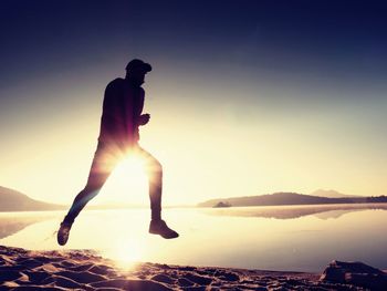 Man running at quiet morning sea. each day morning workout