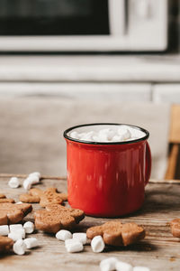 Red cup with cocoa and marshmallows close-up on a wooden background. christmas cookies and  sweets