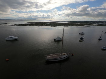 Sailboats moored on sea against sky