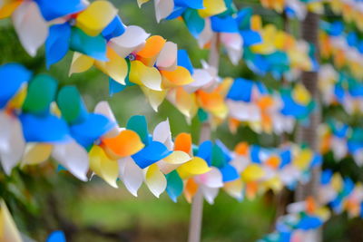 Low angle view of multi colored umbrellas hanging against blue sky