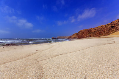 Scenic view of beach against blue sky