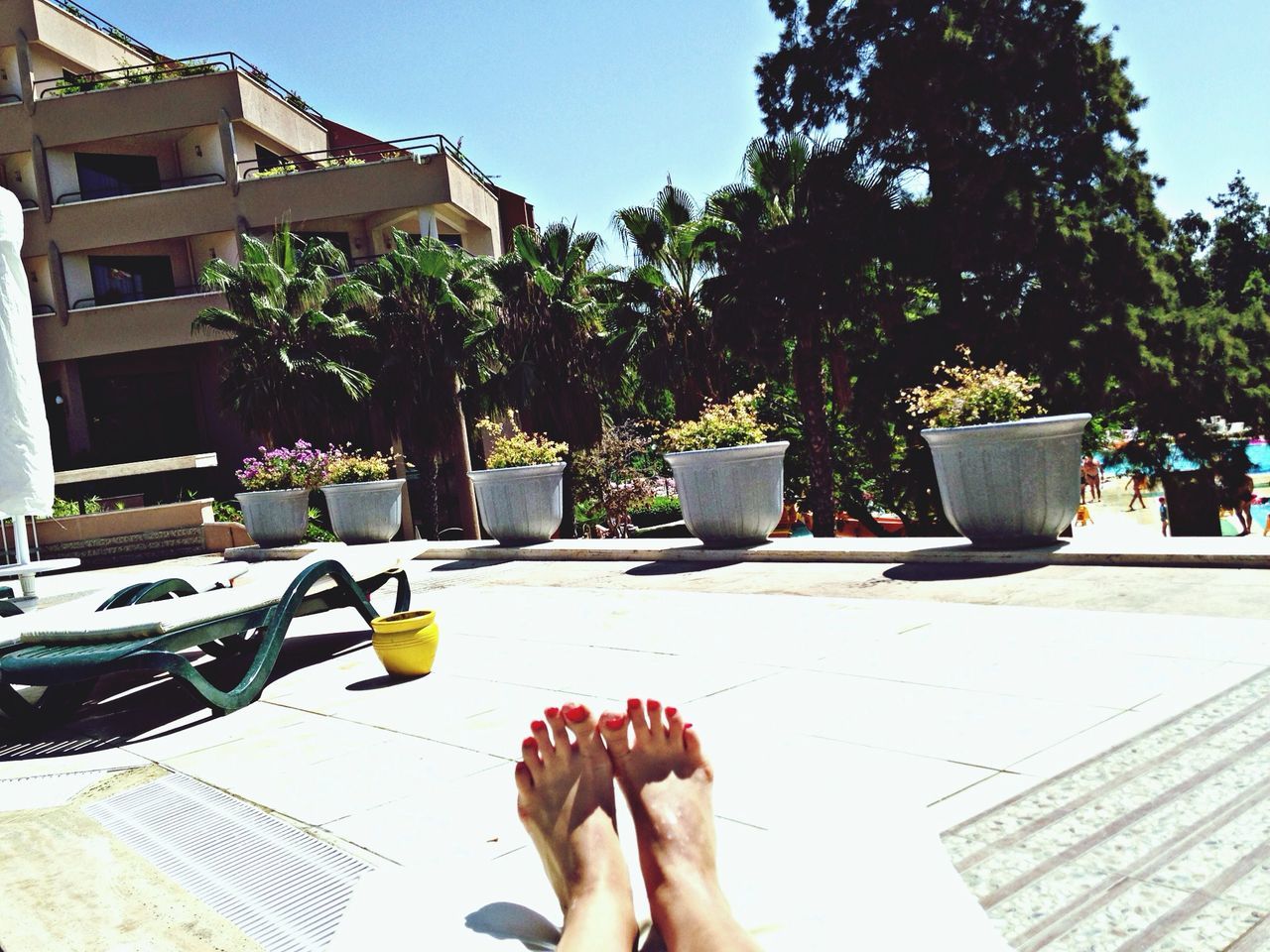 low section, personal perspective, person, lifestyles, barefoot, leisure activity, human foot, sunlight, part of, building exterior, potted plant, relaxation, clear sky, men, tree, unrecognizable person