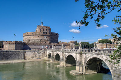 Arch bridge over river against sky