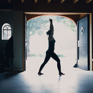 Full length of woman standing in front of window