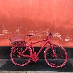 Side view of bicycle parked by wall